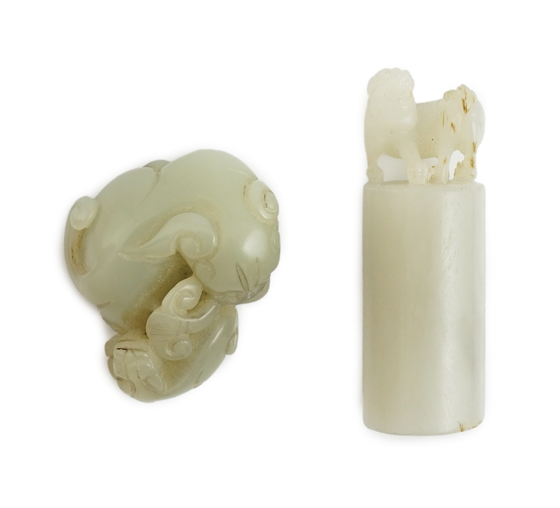 A Chinese white jade lion-dog seal and a Chinese pale celadon jade group of a lion dog and cub, 19th century